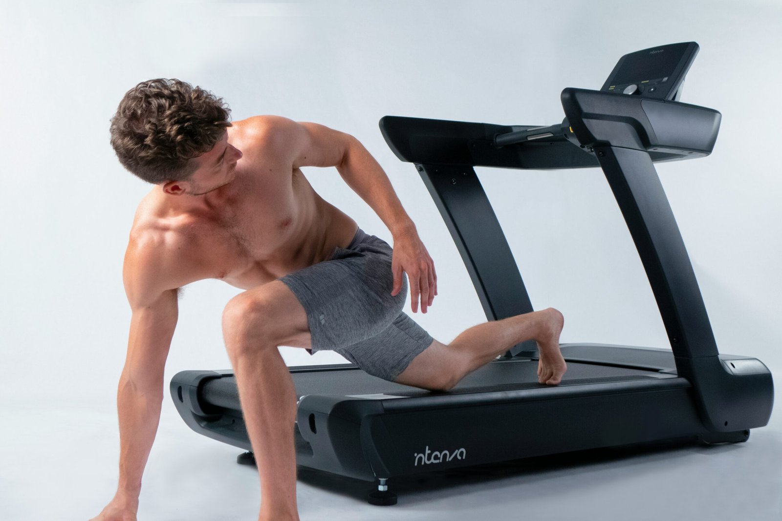 a shirtless man is on a treadmill